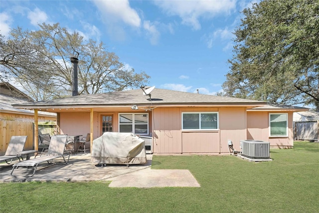 back of property with cooling unit, a patio area, fence, and a lawn