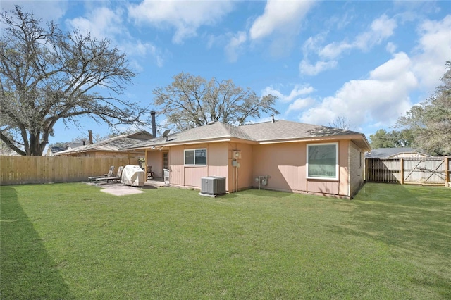 rear view of house with a patio area, a yard, a fenced backyard, and central air condition unit