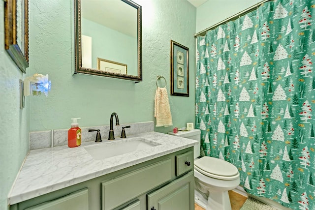 full bath with toilet, a textured wall, and vanity