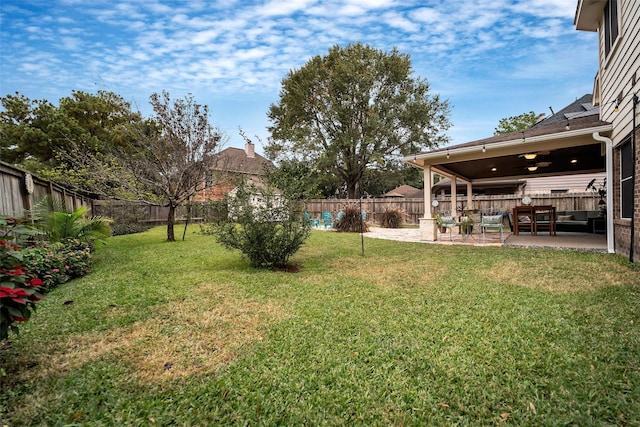 view of yard with a patio area, a fenced backyard, and a ceiling fan