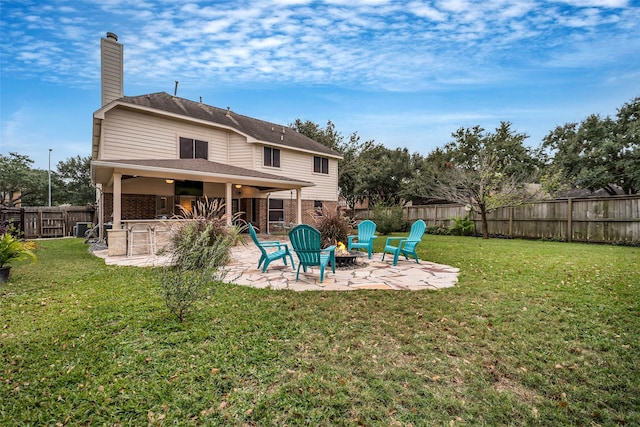 rear view of house with a yard, a patio, a fire pit, and exterior bar