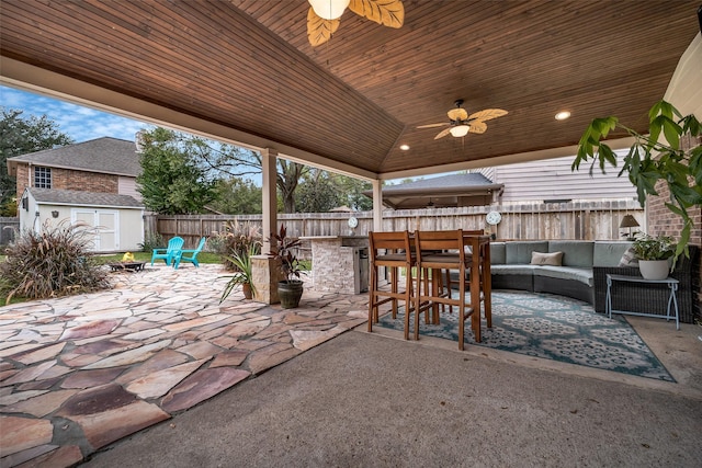 view of patio / terrace with ceiling fan, an outbuilding, a fenced backyard, outdoor lounge area, and a storage unit