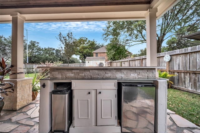 view of patio / terrace with outdoor dry bar, an outdoor kitchen, and a fenced backyard