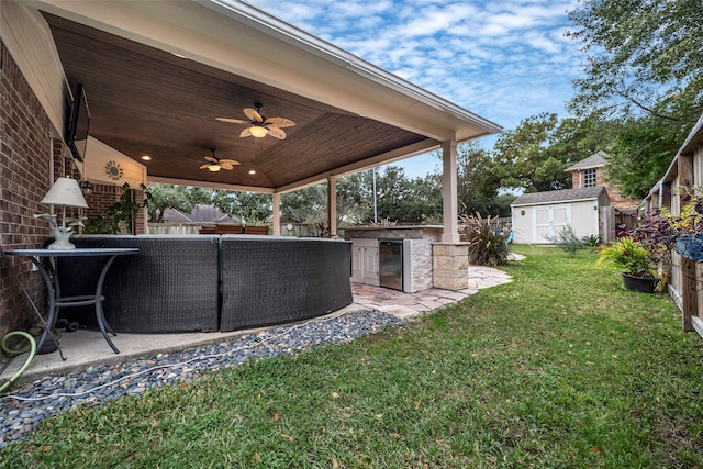 view of yard featuring ceiling fan, a patio, exterior kitchen, and a fenced backyard