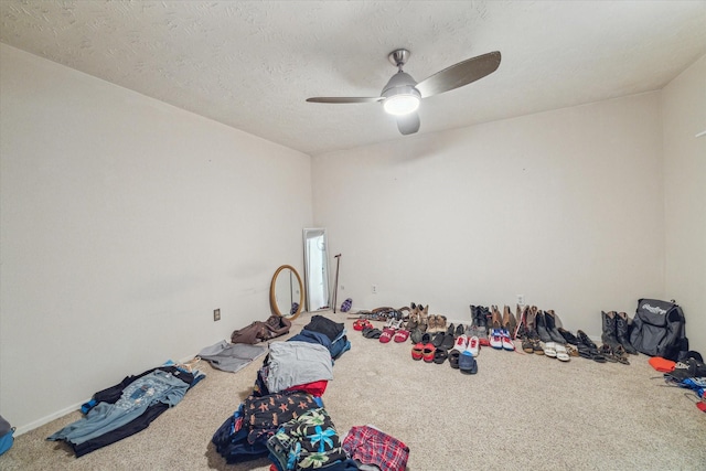 miscellaneous room featuring carpet floors, a textured ceiling, and a ceiling fan