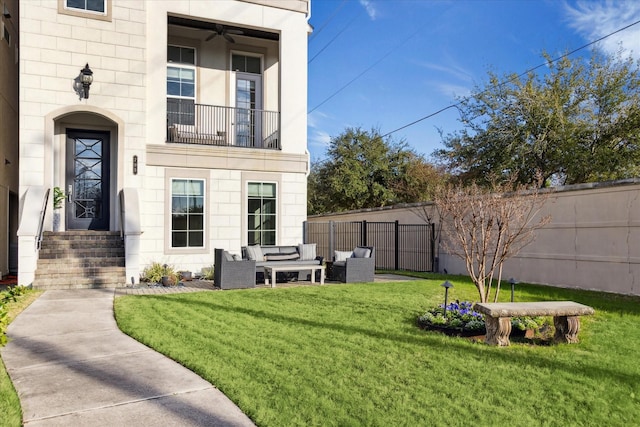 view of yard featuring entry steps, fence, a balcony, and an outdoor hangout area