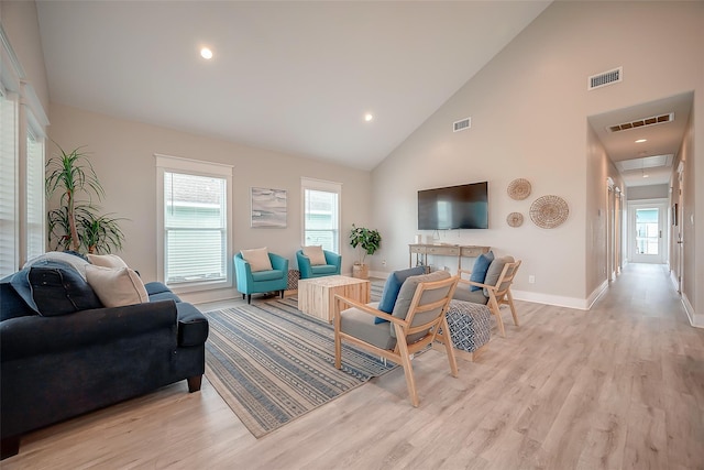 living room featuring attic access, visible vents, and a wealth of natural light