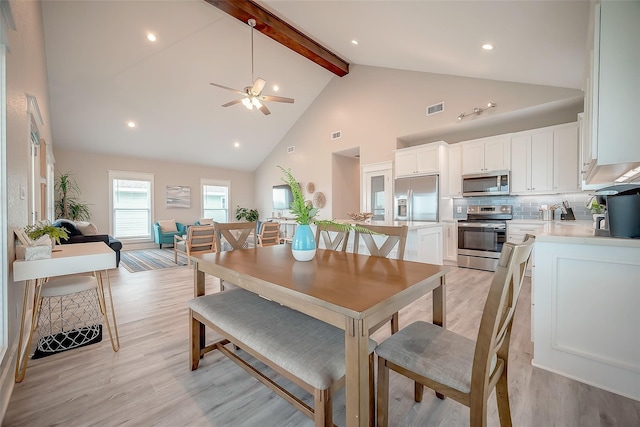 dining room with high vaulted ceiling, beam ceiling, visible vents, and light wood-style floors