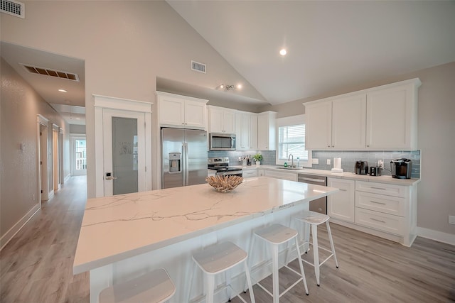 kitchen with stainless steel appliances, a center island, and visible vents