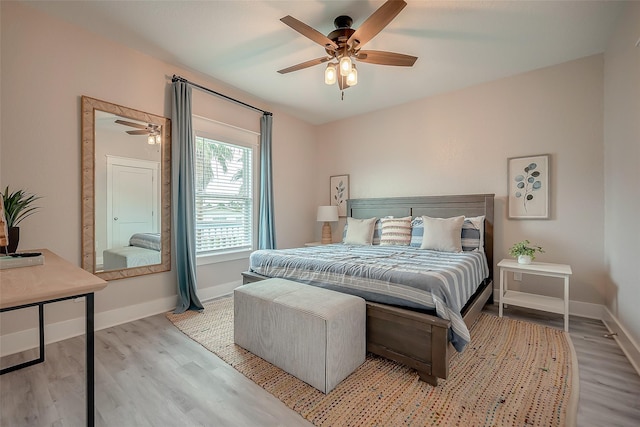 bedroom with light wood-type flooring, baseboards, and a ceiling fan