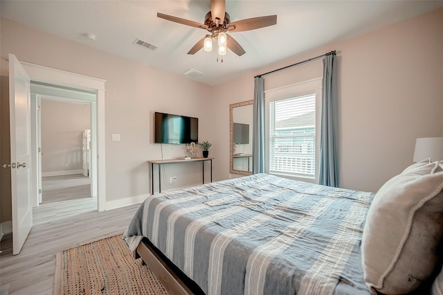 bedroom with light wood finished floors, a ceiling fan, visible vents, and baseboards