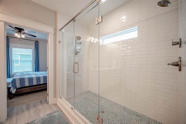 full bath featuring wood finished floors, ceiling fan, a shower stall, and ensuite bathroom