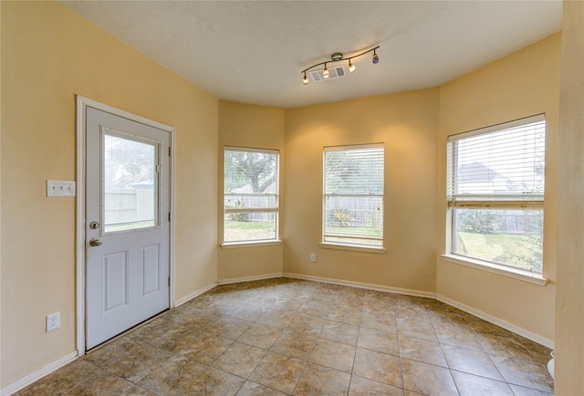 entrance foyer featuring a healthy amount of sunlight, visible vents, and baseboards