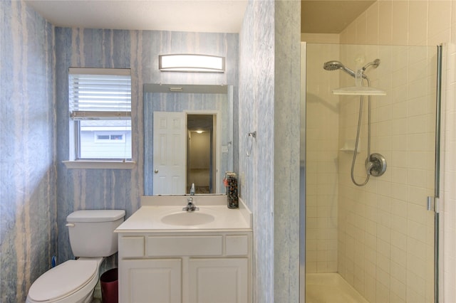 bathroom featuring a stall shower, vanity, toilet, and wallpapered walls