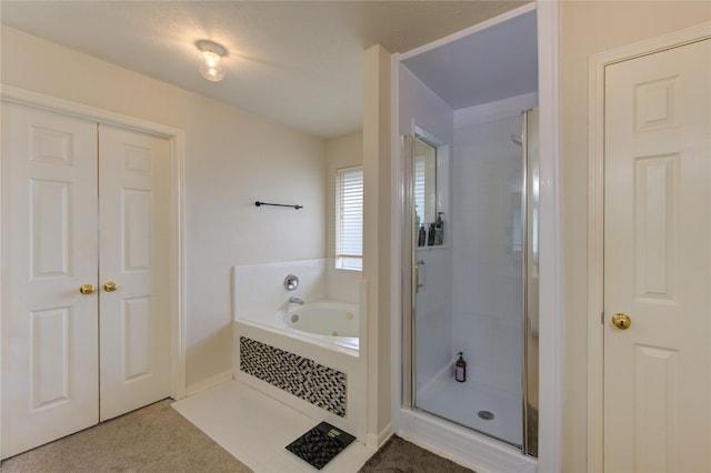 bathroom featuring a closet, a shower stall, and a bath