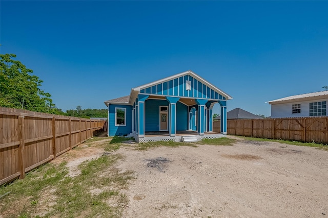 back of property featuring fence and covered porch