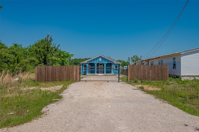 view of road featuring gravel driveway, a gated entry, and a gate
