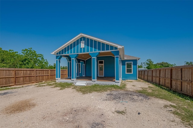 rear view of property with covered porch and fence private yard