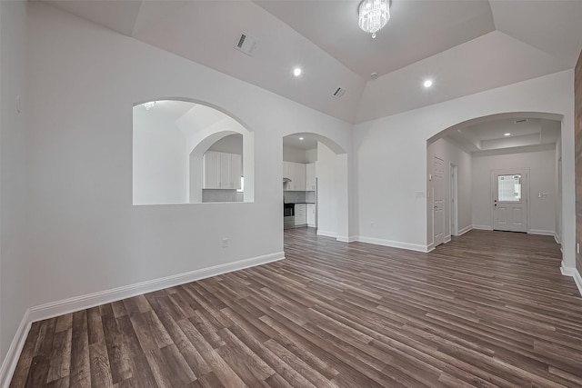 unfurnished living room featuring dark wood finished floors, vaulted ceiling, visible vents, recessed lighting, and baseboards