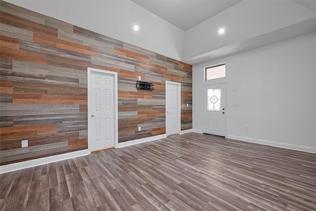 foyer featuring recessed lighting, baseboards, wood finished floors, and a towering ceiling