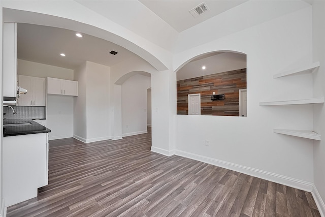 unfurnished living room with dark wood-style flooring, baseboards, visible vents, and recessed lighting