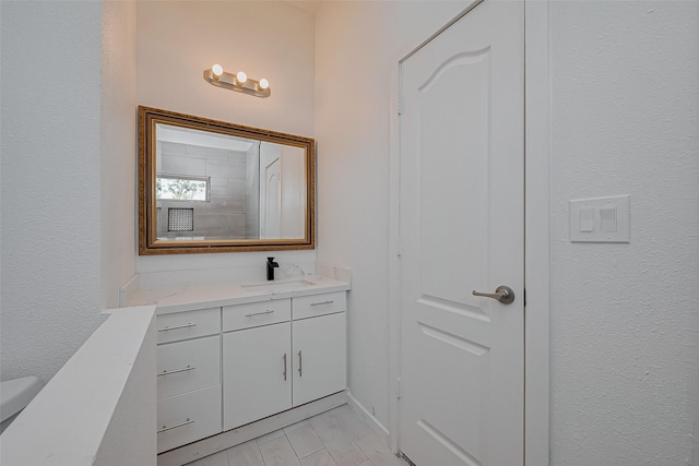 bathroom with vanity and a textured wall
