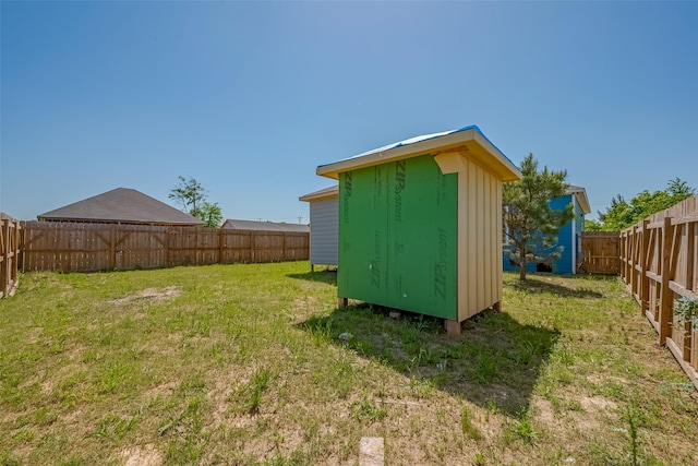 view of yard featuring a fenced backyard, an outdoor structure, and a storage unit