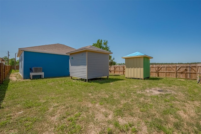 view of yard featuring a shed, a fenced backyard, and an outdoor structure