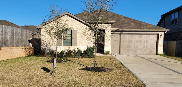 view of front of home with a garage, a shingled roof, fence, driveway, and a front yard