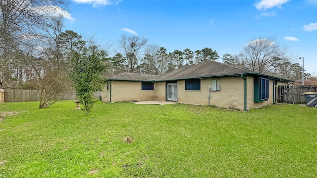 rear view of house with a patio area, a fenced backyard, a lawn, and brick siding