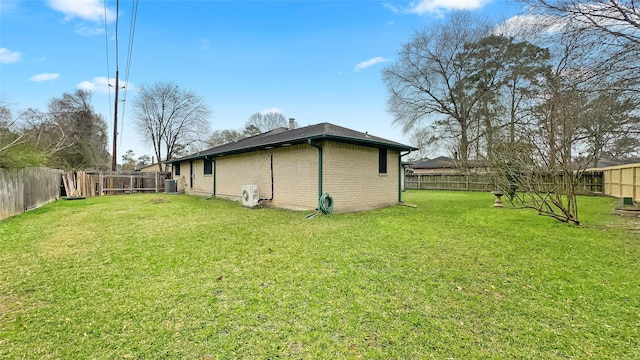 view of yard with central air condition unit and a fenced backyard