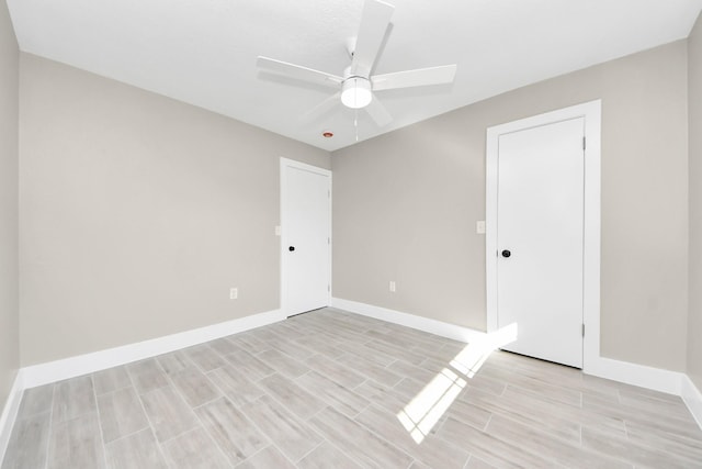 spare room featuring baseboards, a ceiling fan, and wood tiled floor