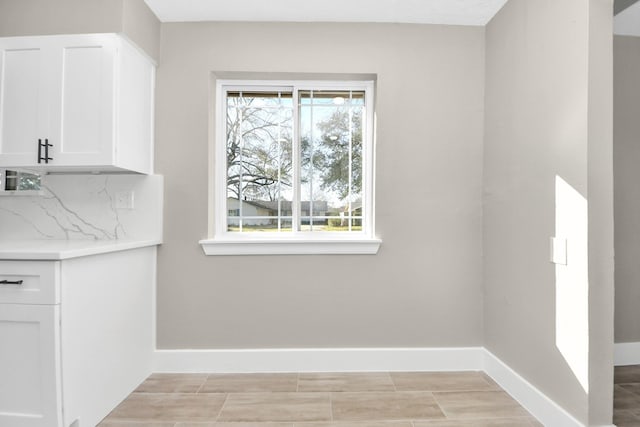 unfurnished dining area with baseboards