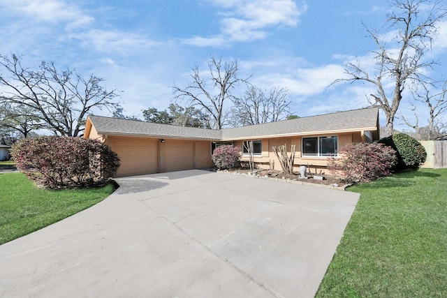 ranch-style home featuring a front lawn, concrete driveway, and an attached garage