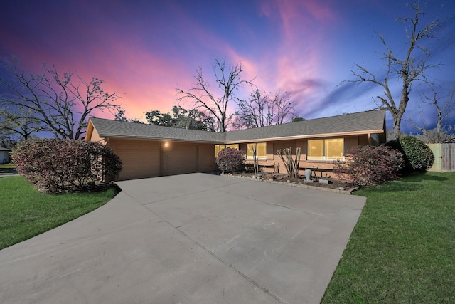 view of front of house with a garage, driveway, and a lawn