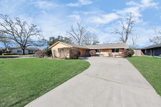 ranch-style house featuring driveway and a front lawn