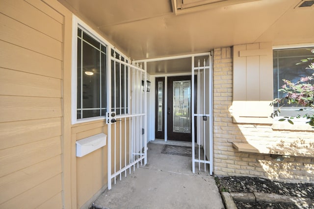 entrance to property with brick siding and visible vents