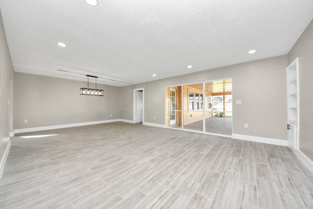 empty room with light wood-style floors, recessed lighting, and baseboards