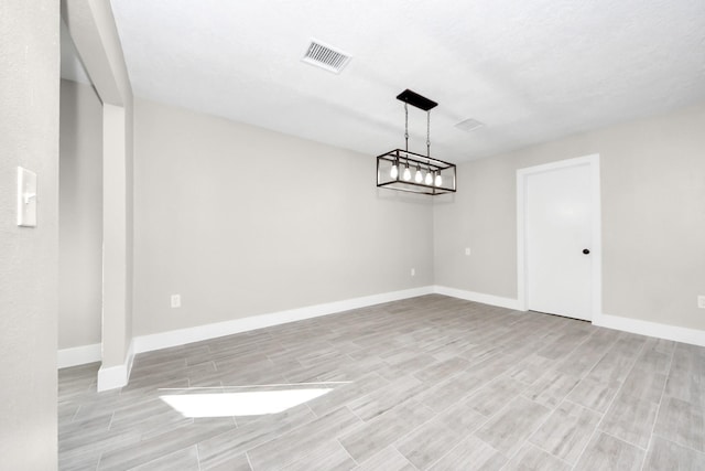 unfurnished dining area with wood finish floors, visible vents, and baseboards