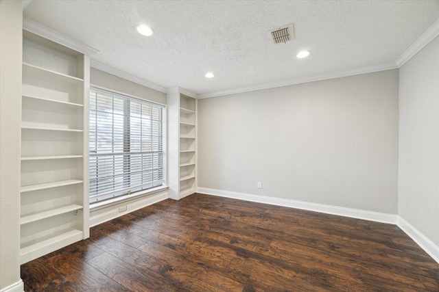 empty room featuring visible vents, dark wood-type flooring, ornamental molding, a textured ceiling, and baseboards