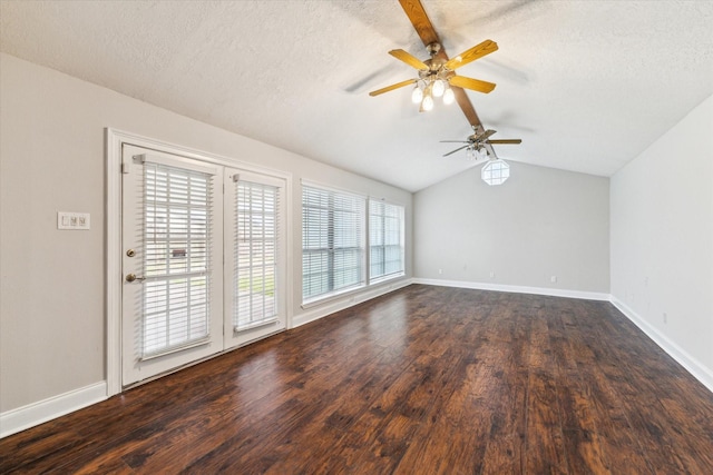 spare room featuring lofted ceiling with beams, dark wood-style flooring, a textured ceiling, and baseboards