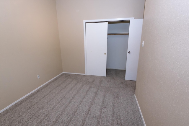 unfurnished bedroom featuring a closet, carpet flooring, and baseboards