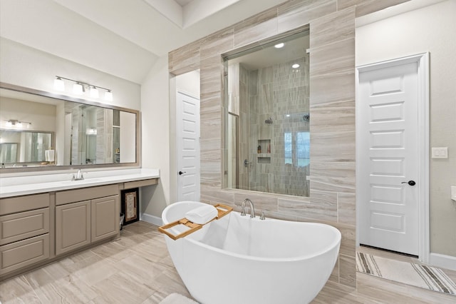 full bath featuring a freestanding tub, baseboards, a tile shower, and vanity