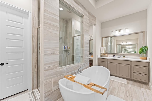 full bathroom featuring a soaking tub, a shower stall, and vanity