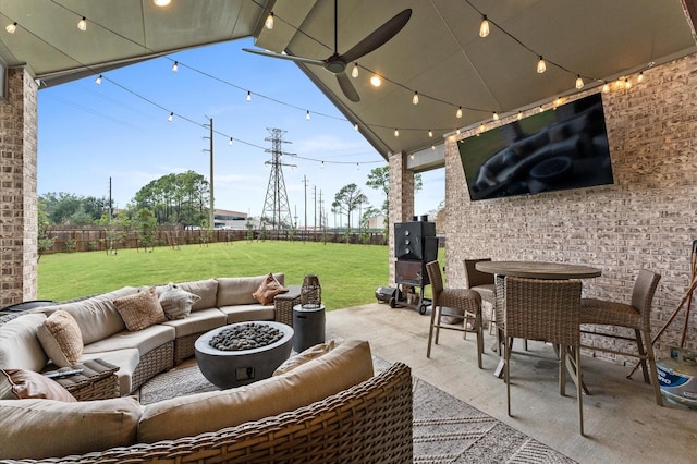 view of patio featuring an outdoor living space with a fire pit, ceiling fan, and a fenced backyard