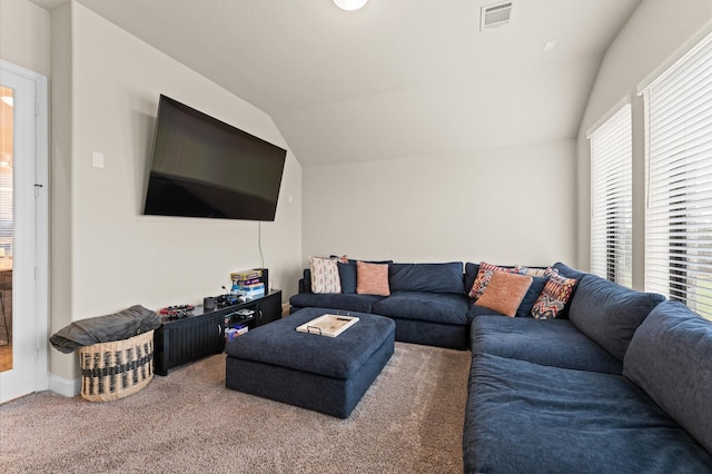 carpeted living area with lofted ceiling and visible vents