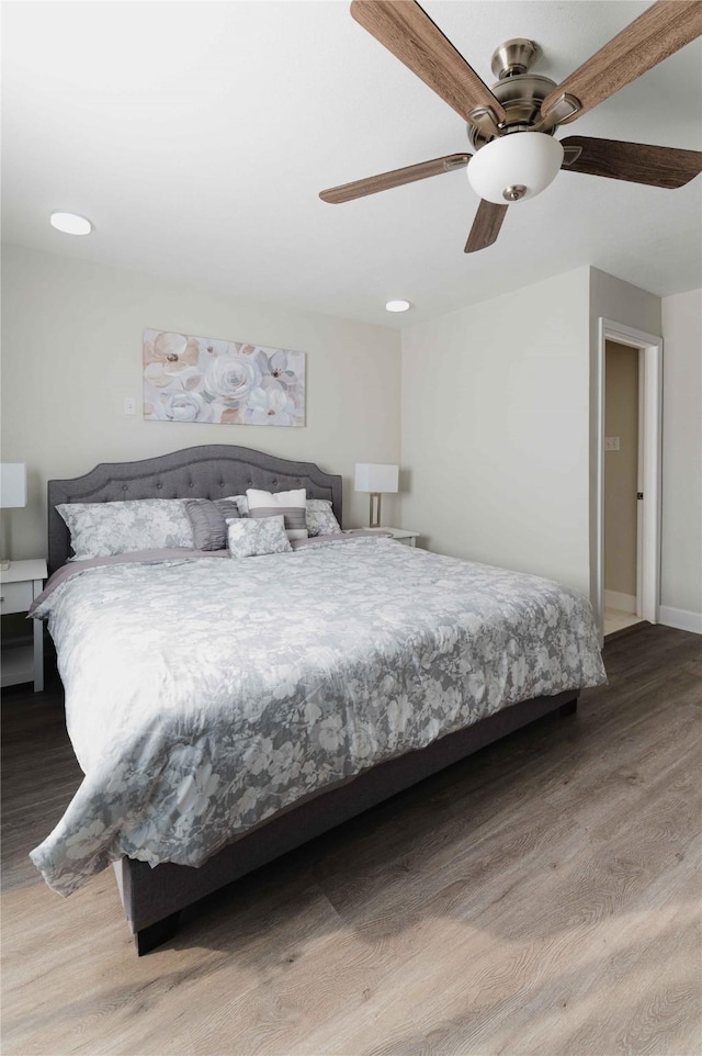 bedroom with baseboards, a ceiling fan, and wood finished floors