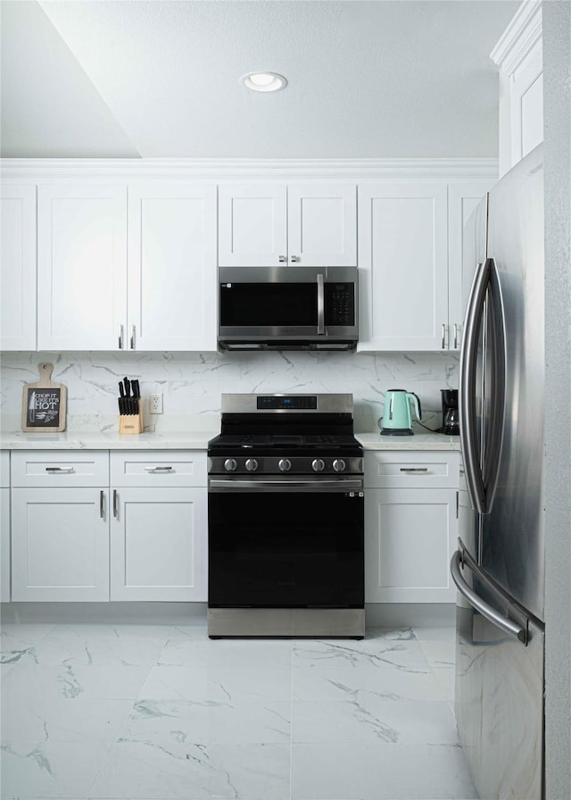 kitchen featuring appliances with stainless steel finishes, light countertops, and white cabinets