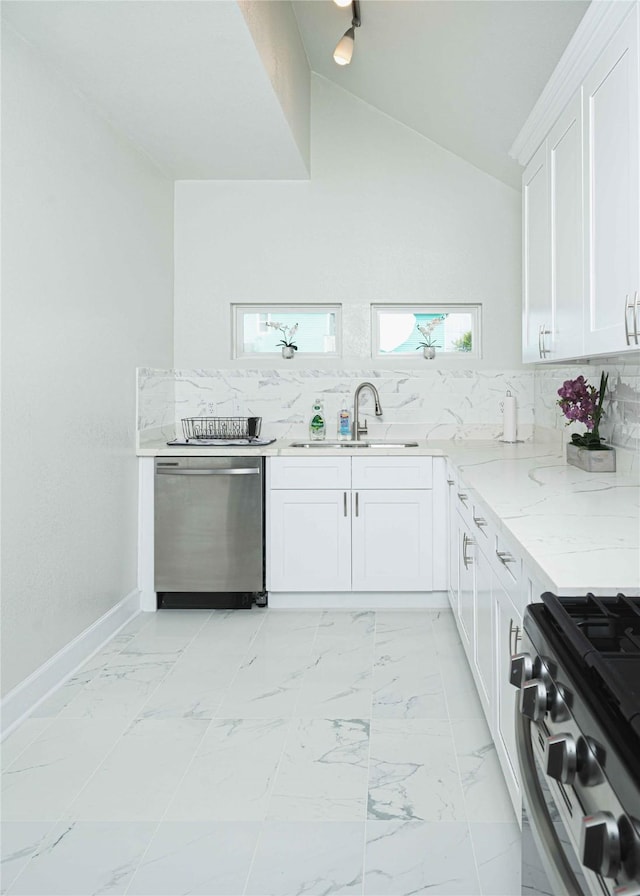 kitchen featuring a sink, white cabinets, marble finish floor, stainless steel dishwasher, and light stone countertops