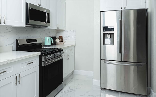 kitchen featuring appliances with stainless steel finishes, marble finish floor, white cabinetry, and light stone counters